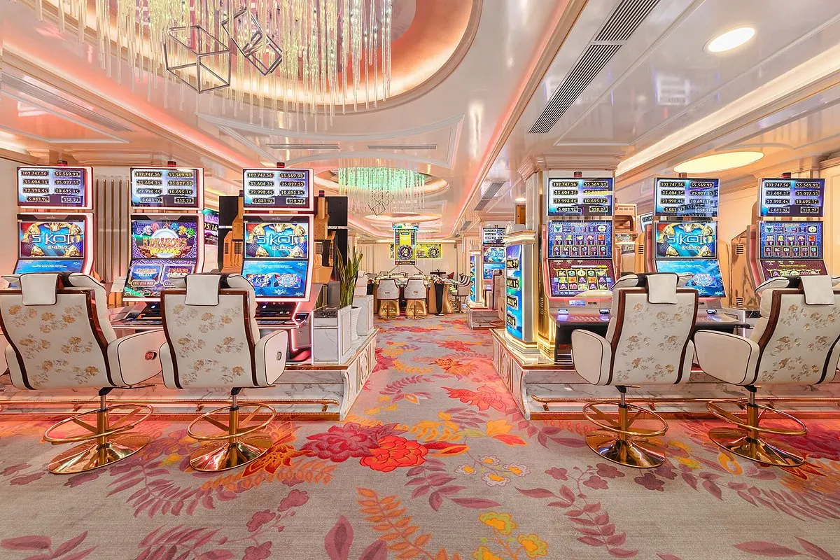 Exterior view of Club Vegas Casino with its grand facade illuminated by colorful lights, prominent signage displaying the casino's name, and patrons entering through the main entrance, showcasing a vibrant and inviting nightlife destination.