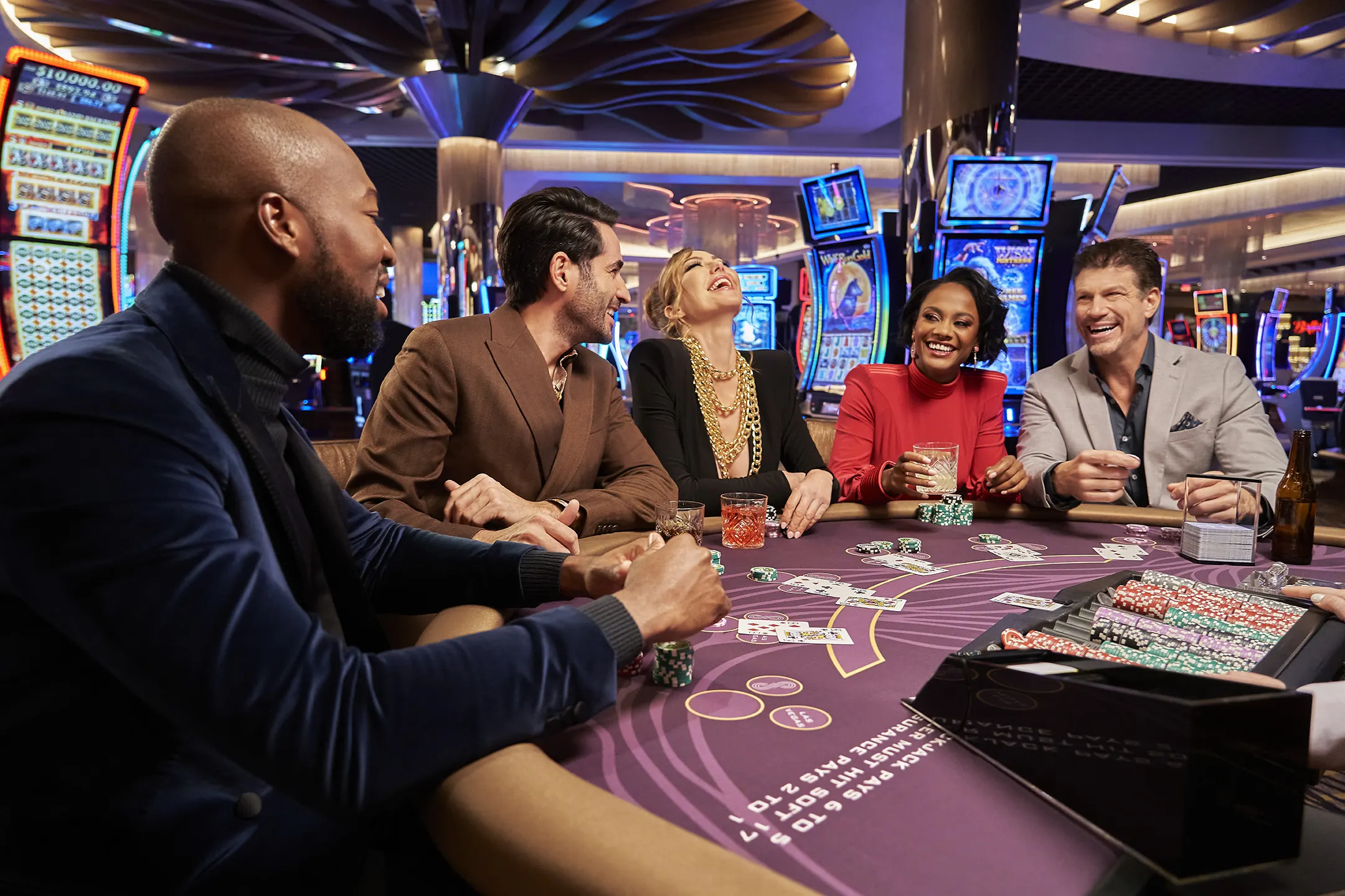 A bustling blackjack table inside a casino in Vietnam, with players actively engaged in the game, a dealer dealing cards, and the vibrant casino interior adorned with colorful lights and decorations.