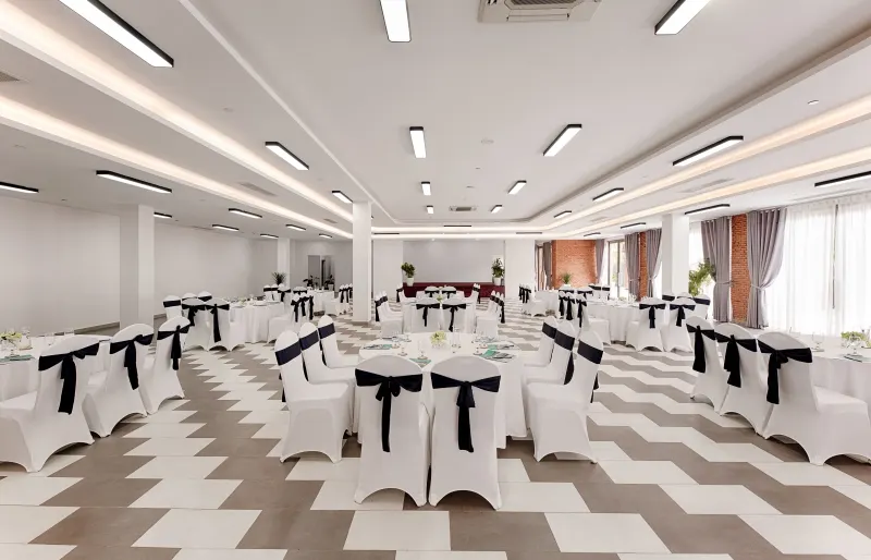 Hình ảnh một buổi gala dinner được tổ chức tại Hội An, với bàn tiệc trang trí sang trọng, ánh đèn lấp lánh và khách mời thưởng thức ẩm thực trong không gian lịch sử và lãng mạn của phố cổ.