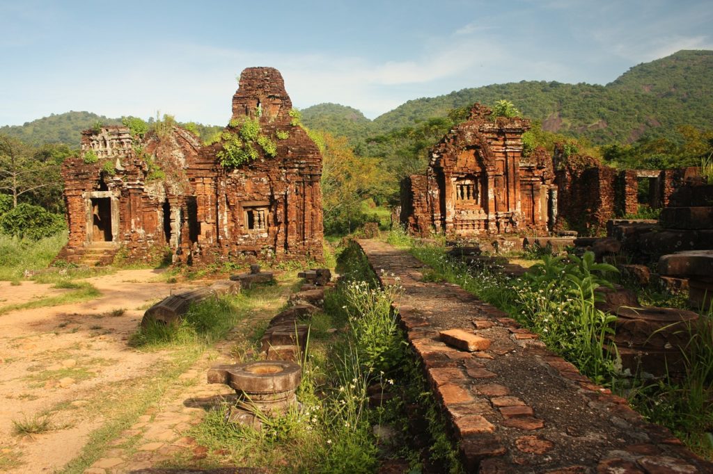 Ancient Cham ruins surrounded by lush greenery, showcasing historical architecture