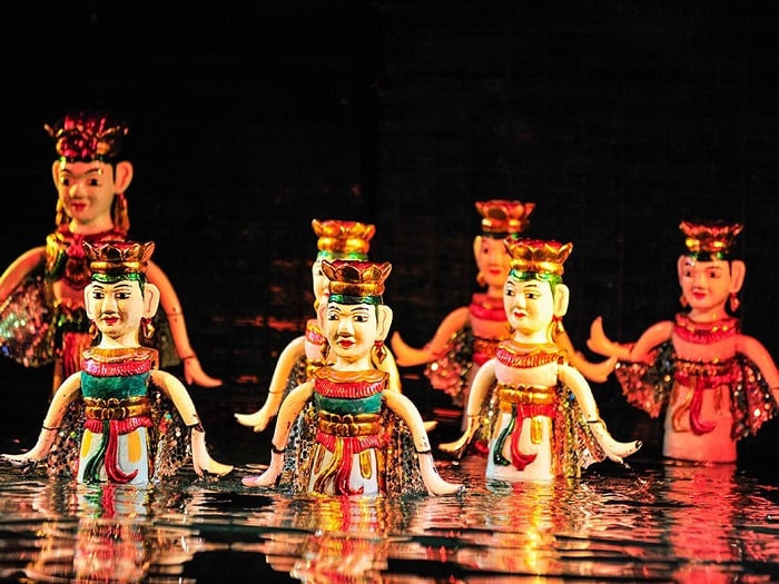 Water puppet performance on a stage with spectators in the background