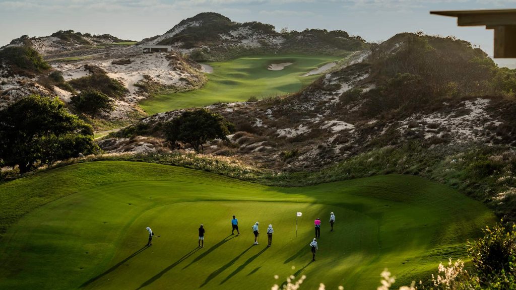 Golfer teeing off with ocean view at The Bluffs, Grand Ho Tram Resort & Casino