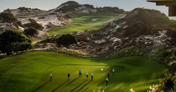 Golfer teeing off with ocean view at The Bluffs, Grand Ho Tram Resort & Casino