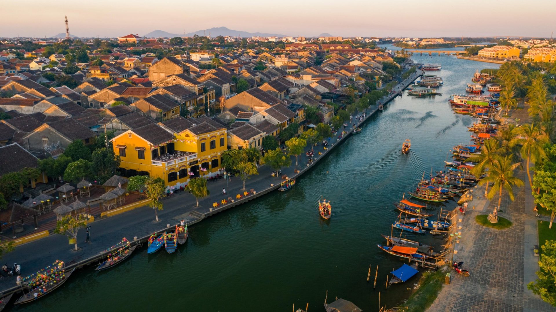 Visitors walking through the ancient town of Hoi An, lined with historic yellow buildings and lanterns