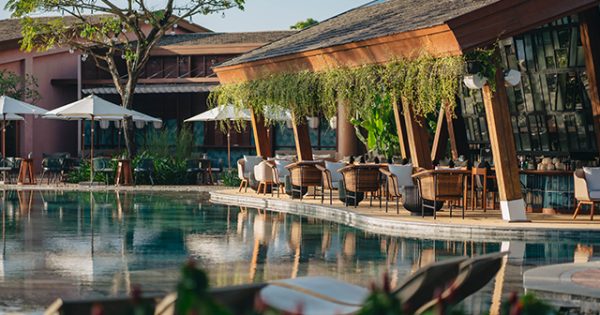 A vibrant scene at a beach club in Hoi An, featuring sun loungers, parasols, and people enjoying the seaside atmosphere