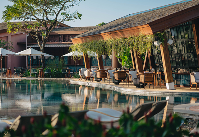 A vibrant scene at a beach club in Hoi An, featuring sun loungers, parasols, and people enjoying the seaside atmosphere