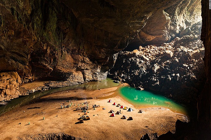 Stunning view inside Phong Nha-Ke Bang Cave showcasing intricate limestone formations, stalactites, and an underground river flowing through the cavern