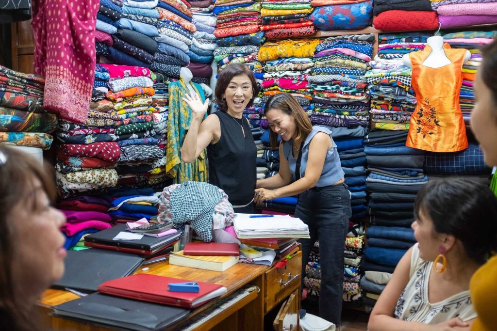 Skilled tailors creating custom clothing in a Hoi An shop