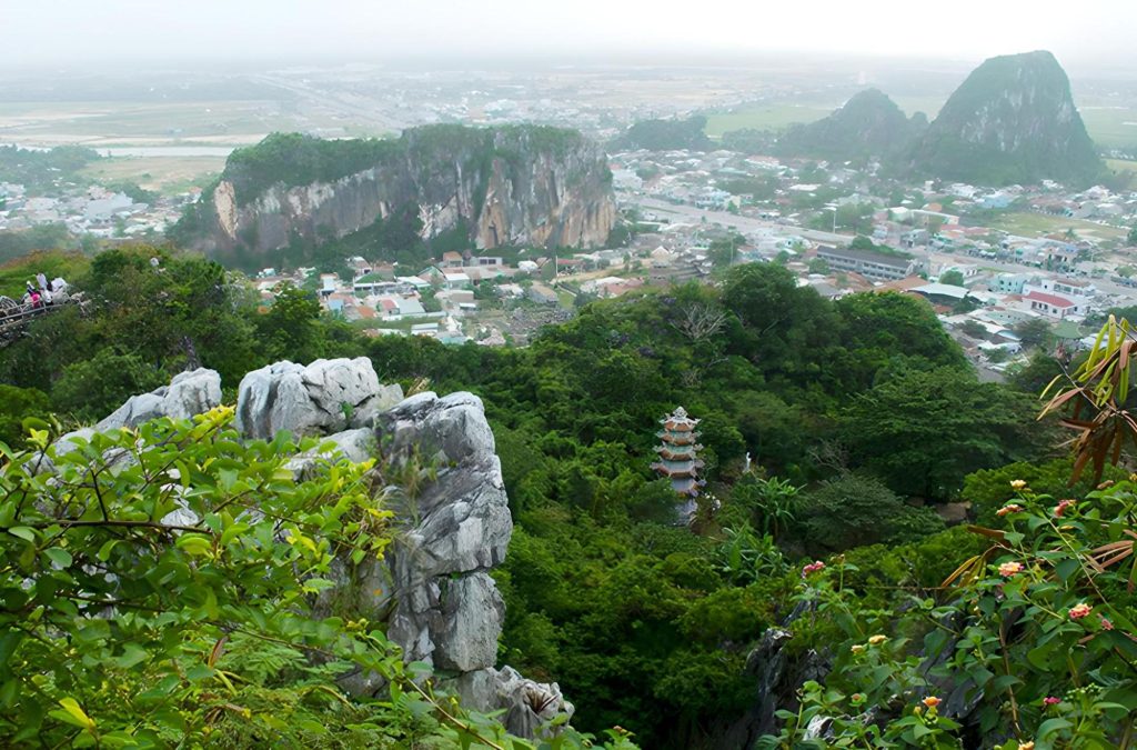 Toàn cảnh quần thể Ngũ Hành Sơn với năm ngọn núi đá vôi lớn lao, xung quanh vày cây cối và những ngôi miếu cổ kính