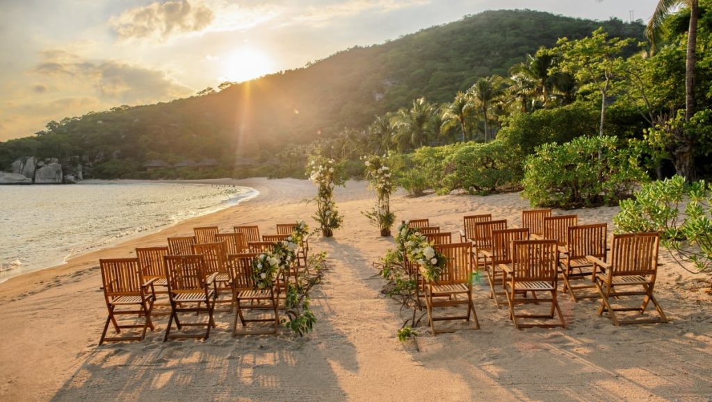 A wedding setup at Six Senses Ninh Van Bay, featuring a natural beach and mountain scenery.