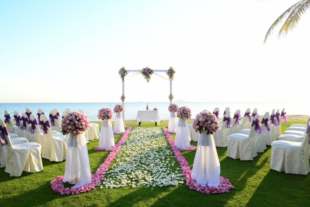 A couple working with a wedding planner on the beach in Vietnam, surrounded by wedding décor.