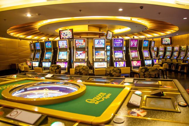 Không gian nội thất sang trọng tại Club Royale với các bàn chơi bài và máy slot.