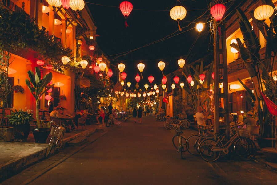 People gathering around lanterns during the Hoi An Lantern Festival, reflecting the cultural significance.