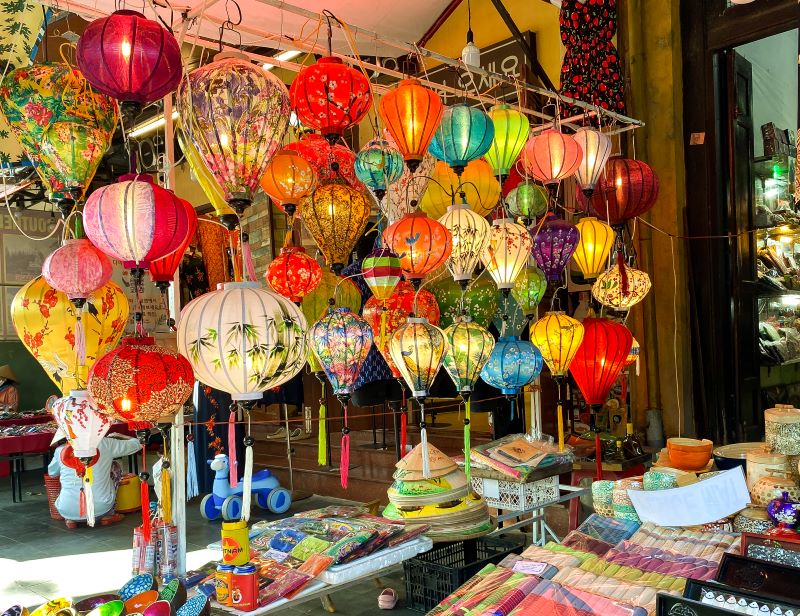 A photographer taking pictures of the illuminated lanterns and river scenes during the Hoi An Lantern Festival.