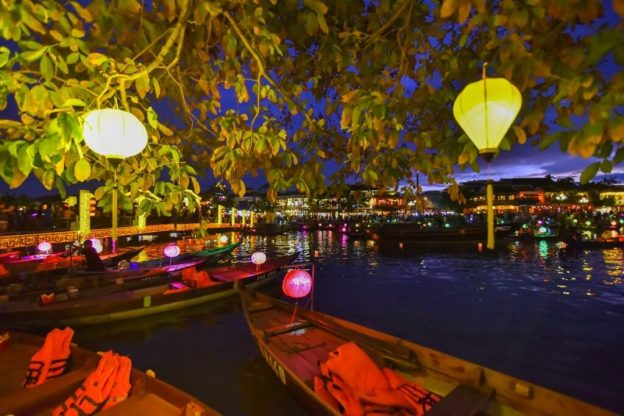 A boat ride on the Hoai River, with lanterns floating above the water during the festival.