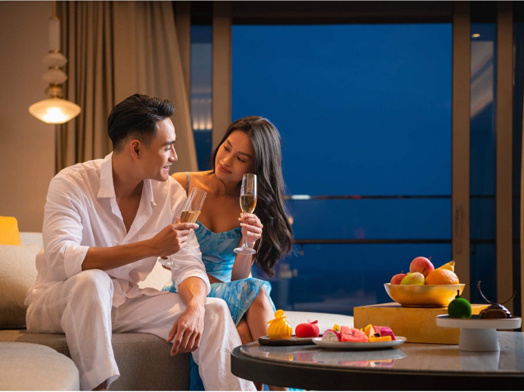 A romantically decorated room with flowers and champagne to welcome a couple.