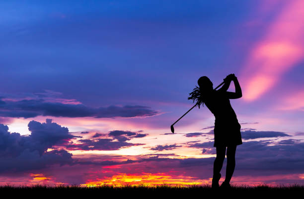  breathtaking twilight view of a golf course surrounded by mountains and illuminated by the setting sun.