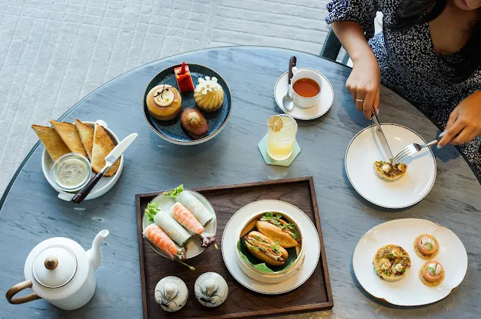 Traditional Vietnamese breakfast spread in Hoi An, featuring a variety of fresh ingredients like pho, banh mi, tropical fruits, and herbal teas, served in a charming local restaurant.