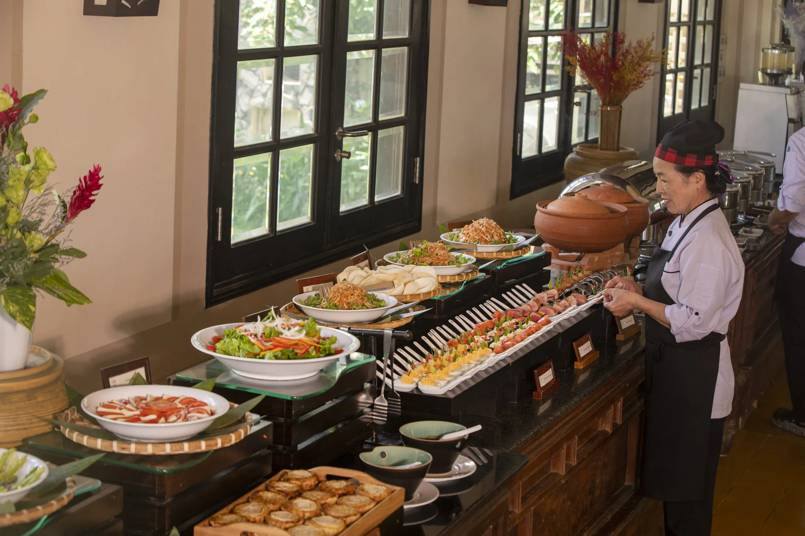 Traditional Vietnamese breakfast spread in Hoi An, featuring a variety of fresh ingredients like pho, banh mi, tropical fruits, and herbal teas, served in a charming local restaurant.