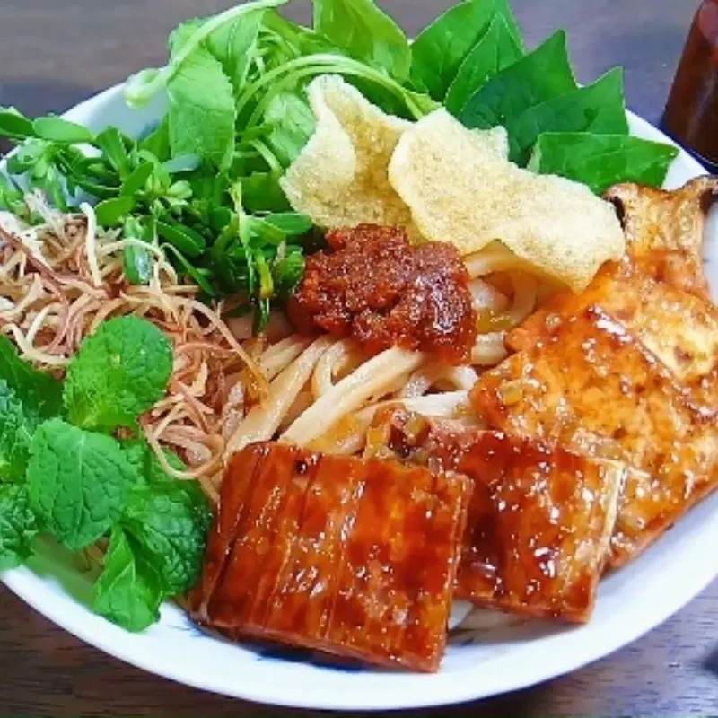 Delicious Cao Lau Hoi An, a traditional Vietnamese dish with rich noodles, pork, and fresh herbs, unique to the city of Hoi An.