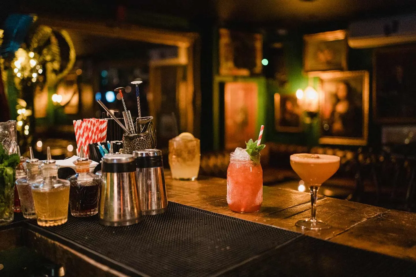 Interior view of a trendy bar in Hoi An, showcasing vibrant décor, cocktails on the counter, and guests enjoying a relaxing evening atmosphere.