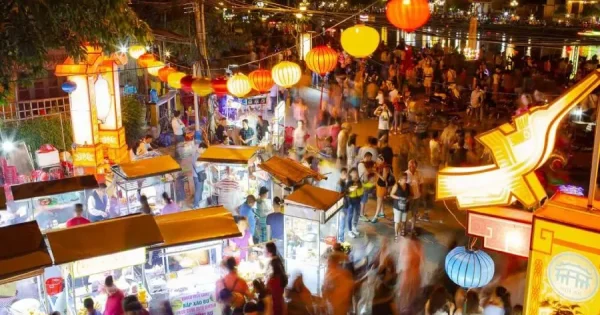 Shimmering lanterns illuminate the bustling Hoi An Night Market, offering visitors a mix of handmade goods and delicious Vietnamese delicacies.