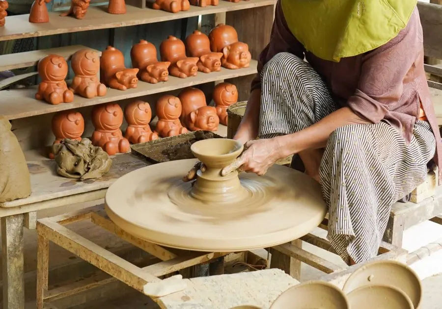 A view of Thanh Ha Pottery Village in Hoi An, showcasing traditional pottery artisans crafting unique ceramic pieces with vibrant colors and intricate designs.