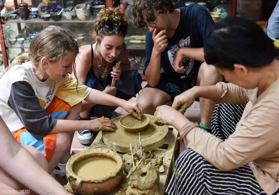 A view of Thanh Ha Pottery Village in Hoi An, showcasing traditional pottery artisans crafting unique ceramic pieces with vibrant colors and intricate designs.