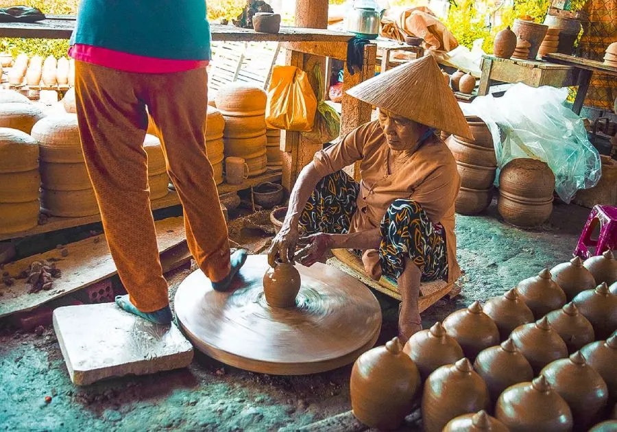 A view of Thanh Ha Pottery Village in Hoi An, showcasing traditional pottery artisans crafting unique ceramic pieces with vibrant colors and intricate designs.