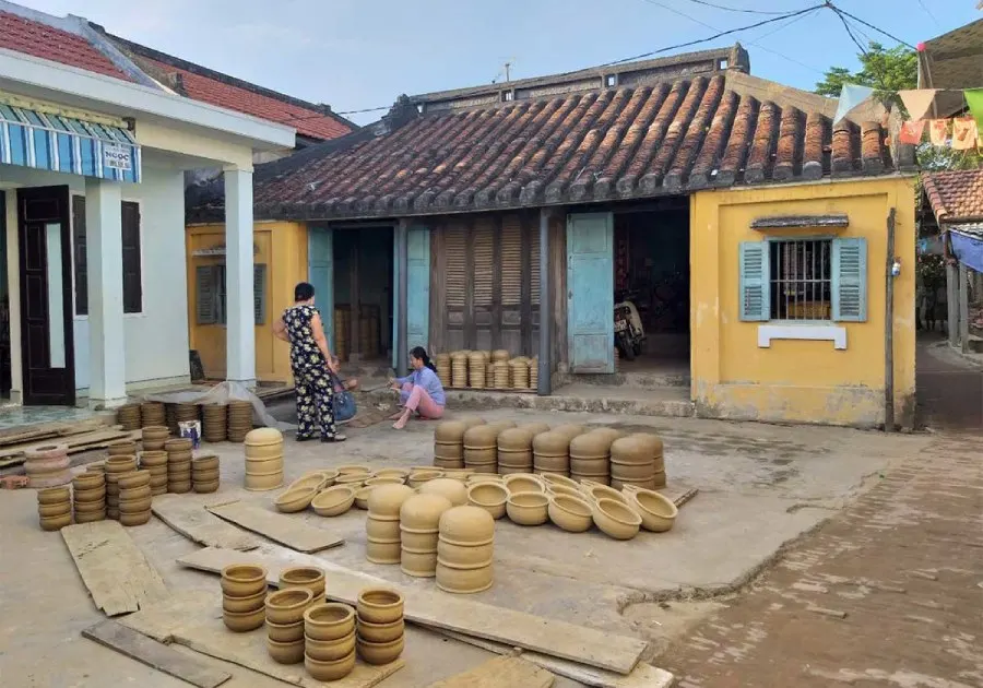 A view of Thanh Ha Pottery Village in Hoi An, showcasing traditional pottery artisans crafting unique ceramic pieces with vibrant colors and intricate designs.