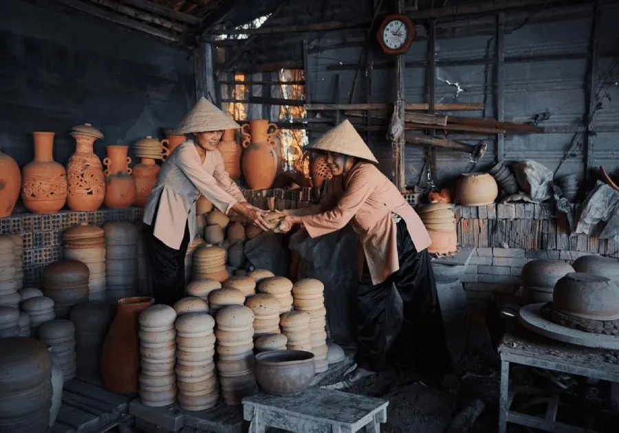 A view of Thanh Ha Pottery Village in Hoi An, showcasing traditional pottery artisans crafting unique ceramic pieces with vibrant colors and intricate designs.