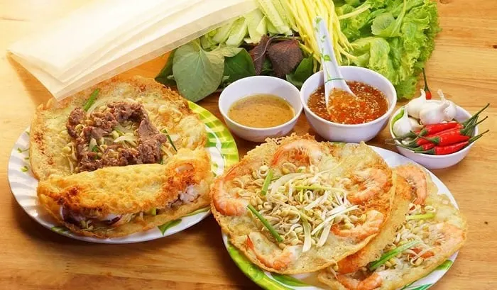 Bánh xèo Hội An – món ăn đặc sản nổi tiếng với vỏ bánh giòn, nhân tôm, thịt và giá, ăn kèm rau sống và nước chấm đậm đà.