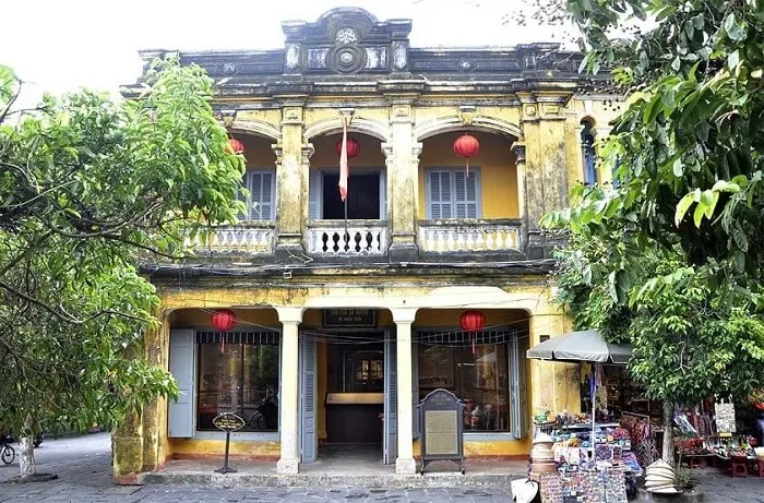 Ảnh chụp bên ngoài bảo tàng Hội An, thể hiện kiến trúc cổ kính với tường vàng đặc trưng và mái ngói đỏ, tạo nên không gian văn hóa đậm chất lịch sử.