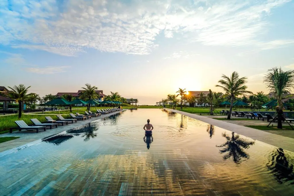 Ảnh chụp một resort cho gia đình tại Hội An với không gian xanh mát, hồ bơi rộng rãi và khu vực vui chơi cho trẻ em, tạo nên điểm đến lý tưởng cho kỳ nghỉ dưỡng gia đình.