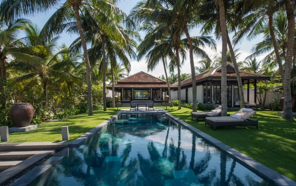 Ảnh chụp một resort cho gia đình tại Hội An với không gian xanh mát, hồ bơi rộng rãi và khu vực vui chơi cho trẻ em, tạo nên điểm đến lý tưởng cho kỳ nghỉ dưỡng gia đình.