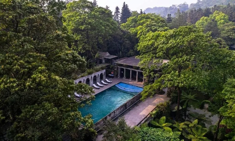 Luxury resort with infinity pool in Vietnam overlooking the ocean, surrounded by tropical greenery and modern architecture.