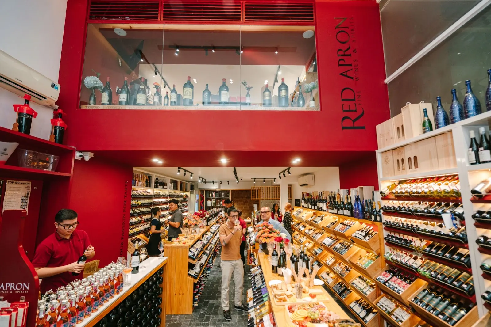 Interior view of a cozy wine shop in Hoi An with wooden shelves displaying a variety of wine bottles.