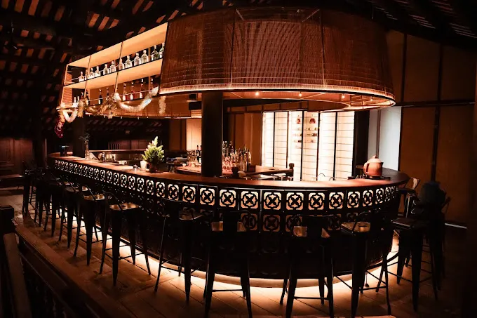 Interior view of a cozy wine shop in Hoi An with wooden shelves displaying a variety of wine bottles.