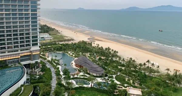 "가을비에 촉촉이 젖은 거리와 은은한 등불이 어우러진 10월의 호이안, 우산을 쓴 여행자들이 고요한 분위기 속을 거니는 모습."
