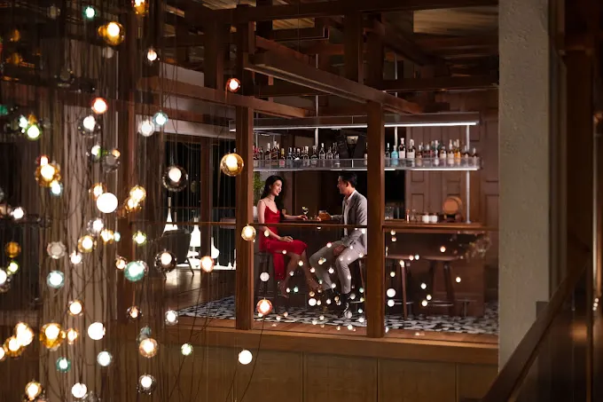 Quầy pha chế đầy màu sắc tại một cocktail bar tại Hội An, nơi du khách thưởng thức đồ uống thủ công trong không gian hiện đại pha nét cổ điển.