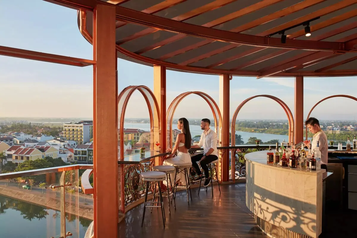 Quầy pha chế đầy màu sắc tại một cocktail bar tại Hội An, nơi du khách thưởng thức đồ uống thủ công trong không gian hiện đại pha nét cổ điển.
