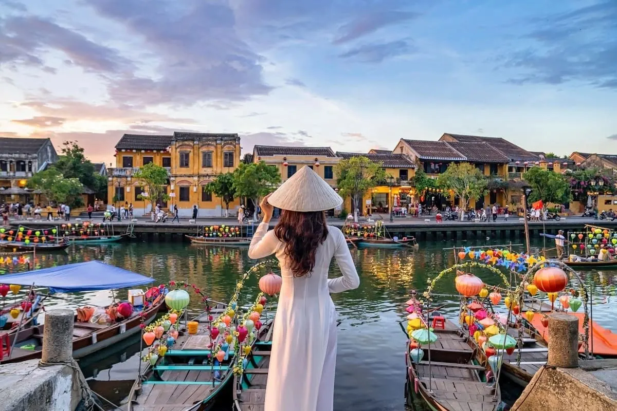 Du khách tận hưởng vẻ đẹp rực rỡ của phố cổ trong chuyến du lịch Hội An tháng 7, giữa những dãy nhà vàng cổ kính và sắc hoa giấy nở rộ.