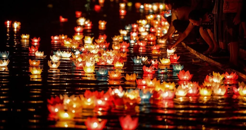 "Peaceful street scene in Hoi An in August, with golden sunlight, colorful lanterns, and locals going about their day in the historic ancient town."