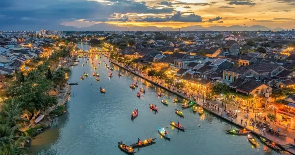 "Peaceful street scene in Hoi An in August, with golden sunlight, colorful lanterns, and locals going about their day in the historic ancient town."
