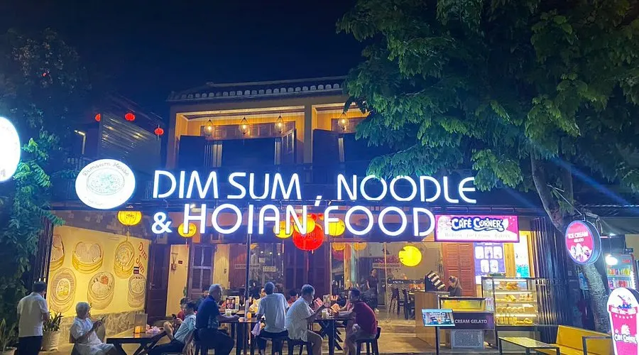 "Traditional Chinese restaurant in Hoi An with classic red lantern decor, round dining tables, and a menu featuring dim sum, Peking duck, and regional specialties."
