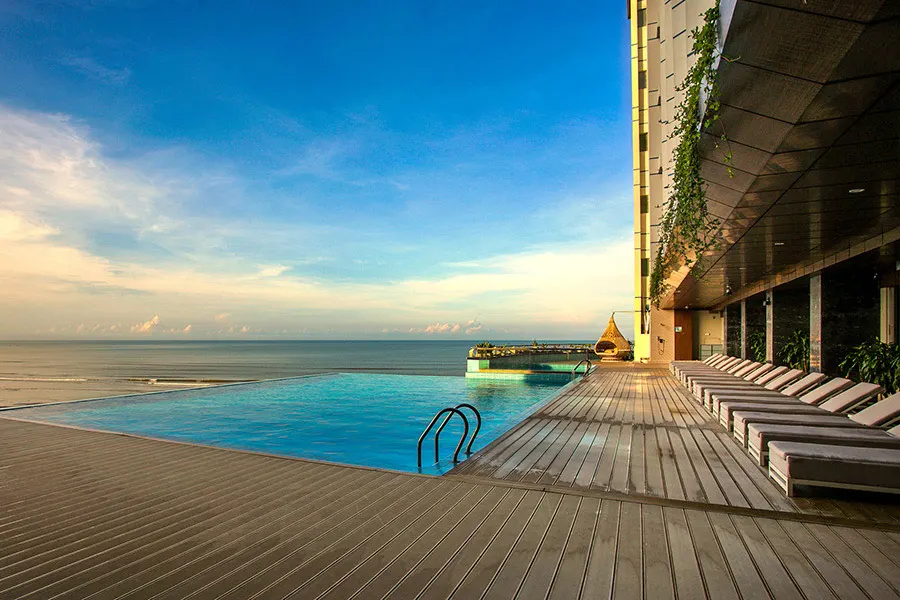 Khung cảnh thư giãn tại resort có bể bơi vô cực tại Hội An, với tầm nhìn hướng ra thiên nhiên yên bình và thiết kế sang trọng giữa không gian mở.