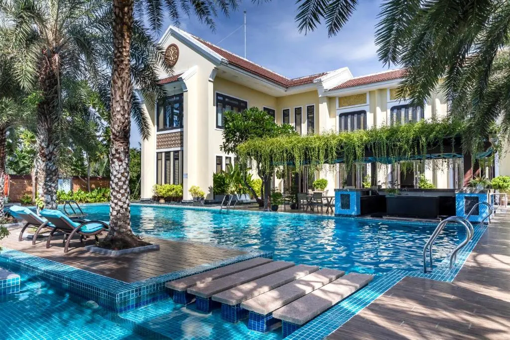 Khung cảnh thư giãn tại resort có bể bơi vô cực tại Hội An, với tầm nhìn hướng ra thiên nhiên yên bình và thiết kế sang trọng giữa không gian mở.