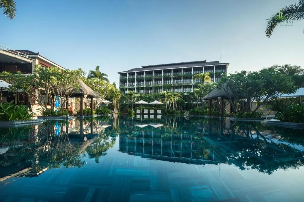 Khung cảnh thư giãn tại resort có bể bơi vô cực tại Hội An, với tầm nhìn hướng ra thiên nhiên yên bình và thiết kế sang trọng giữa không gian mở.