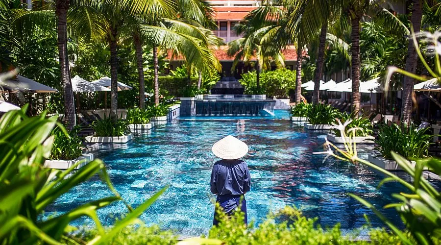 Khung cảnh thư giãn tại resort có bể bơi vô cực tại Hội An, với tầm nhìn hướng ra thiên nhiên yên bình và thiết kế sang trọng giữa không gian mở.