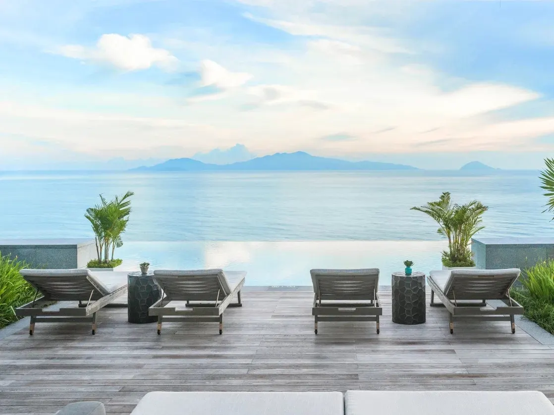Khung cảnh thư giãn tại resort có bể bơi vô cực tại Hội An, với tầm nhìn hướng ra thiên nhiên yên bình và thiết kế sang trọng giữa không gian mở.